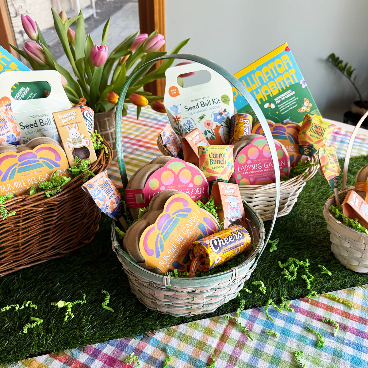 Colorful limited edition Easter baskets filled with seed kits, snacks, and gardening items, displayed on a checkered tablecloth.