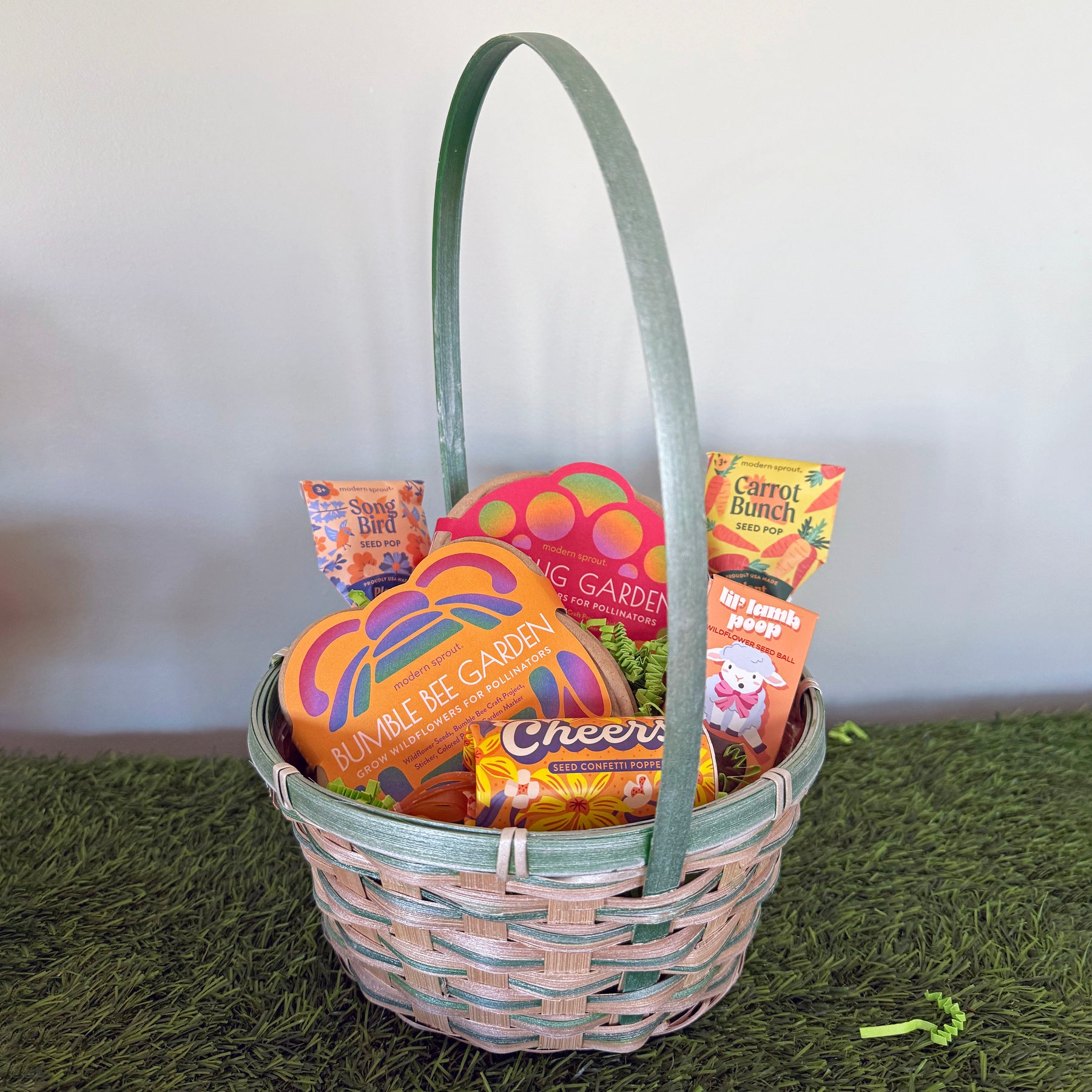 A woven Easter basket filled with colorful treats, including garden-themed items and cheerful snacks, set on green grass.