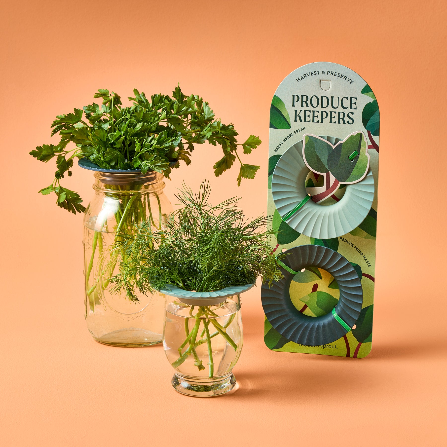 Two jars filled with fresh herbs, featuring Produce Keepers packaging, designed to extend the life of produce.