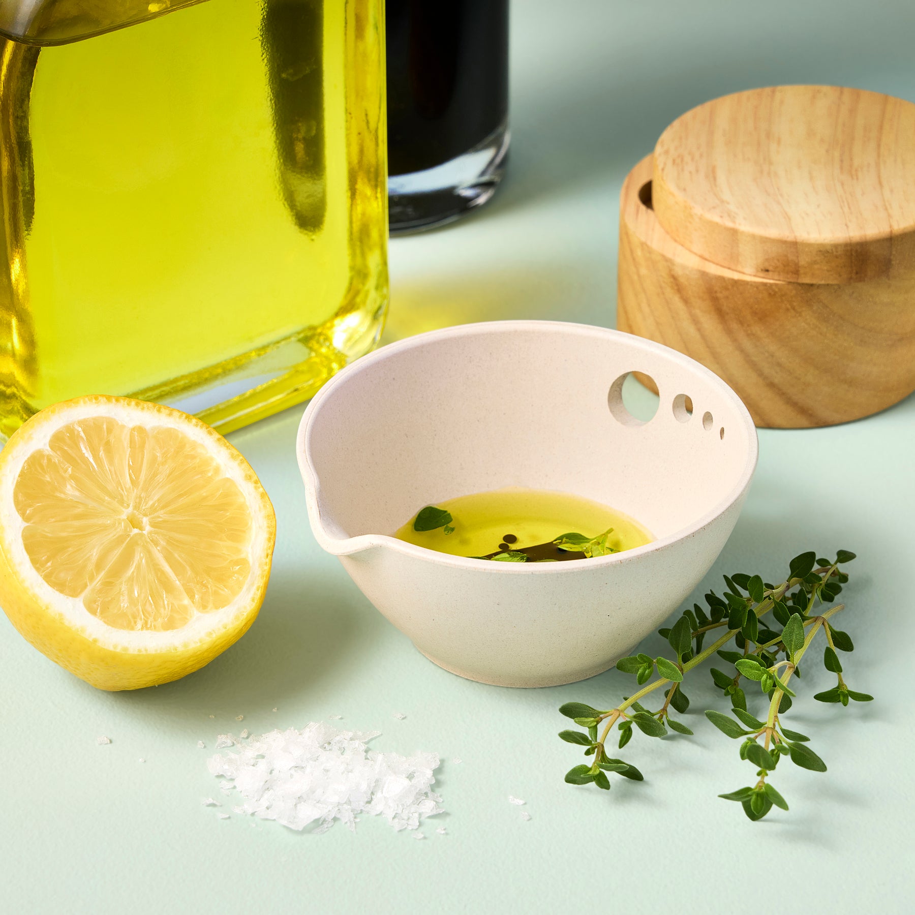 Peel, Grate & Prep Dish with olive oil, lemon half, fresh thyme, and salt on a pastel background.