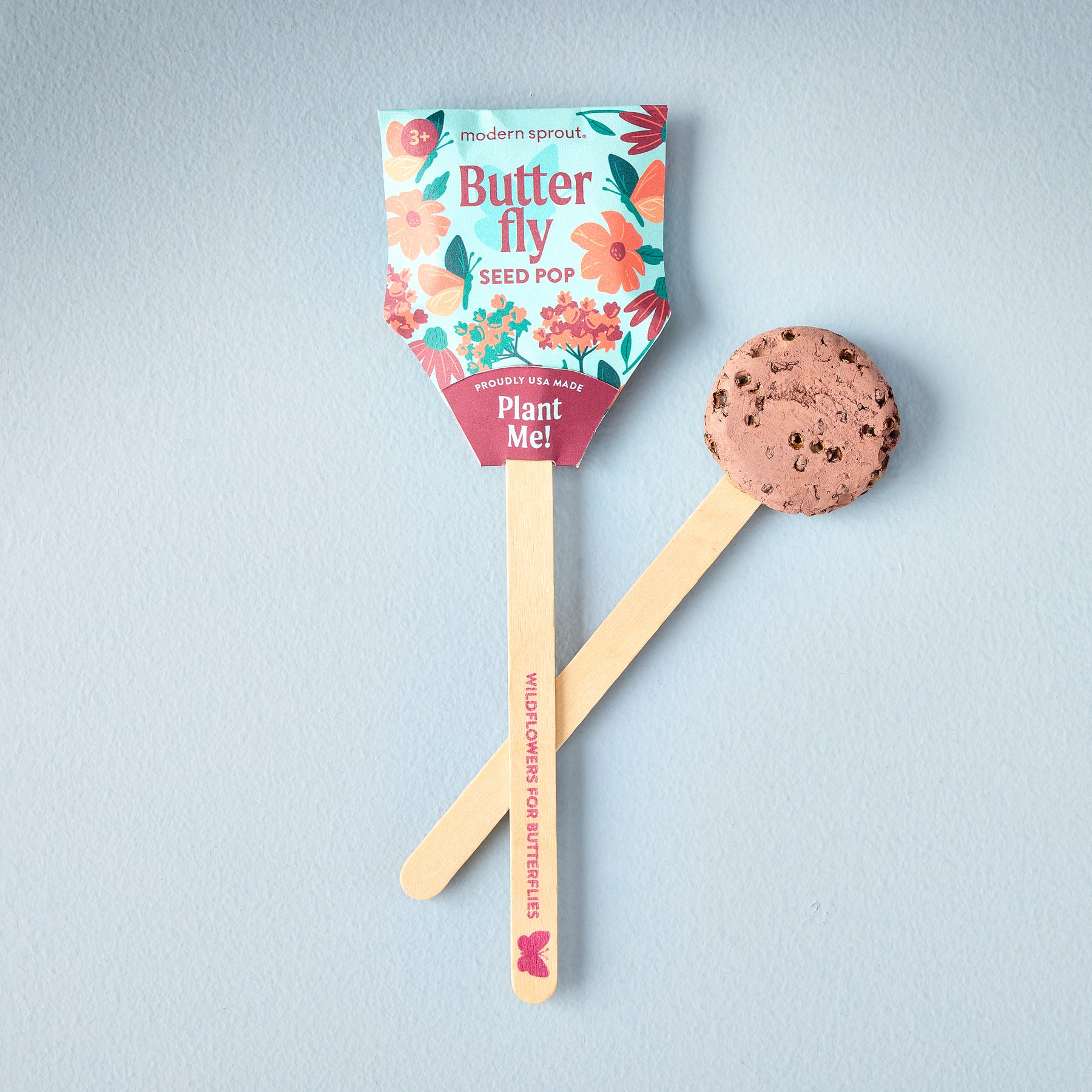Seed Pops Pollinator featuring a butterfly design, with a biodegradable seed disk on a wooden stick for planting.
