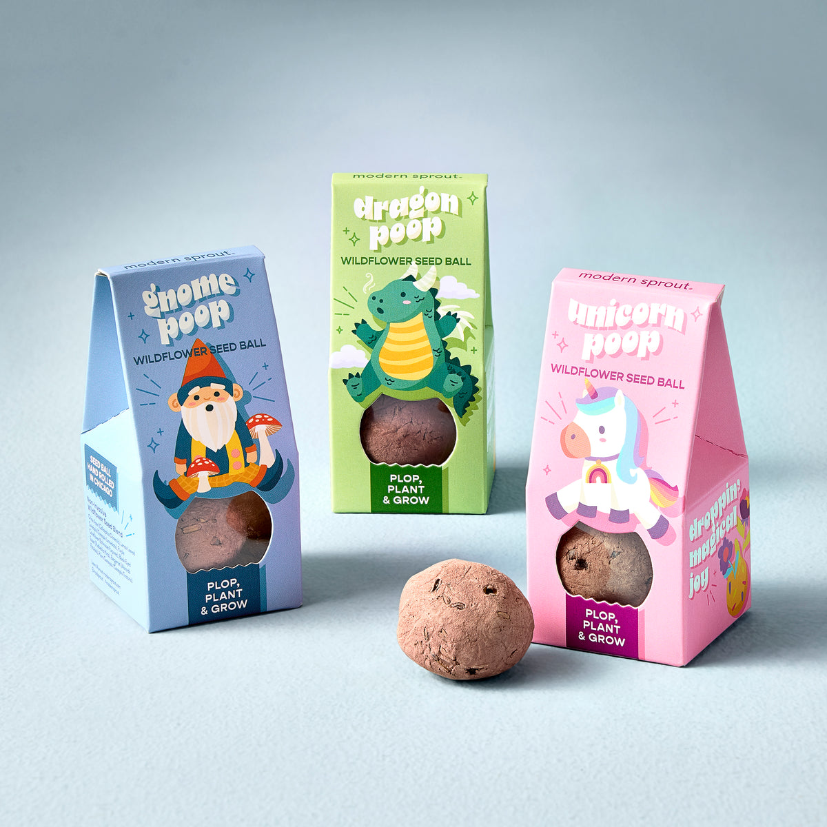 Colorful seed ball packaging for Magical Plops, featuring whimsical designs of gnomes, dragons, and unicorns.