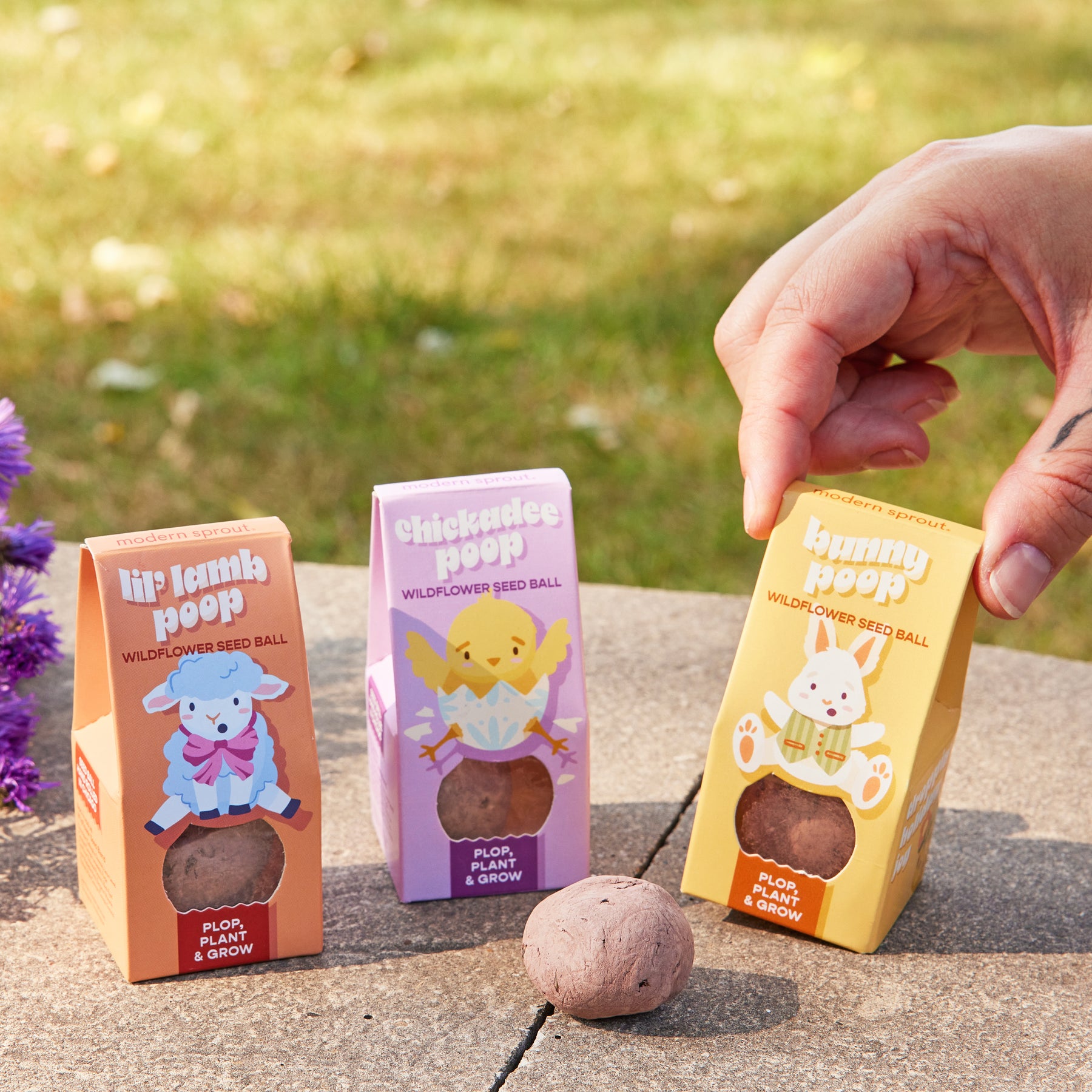 Colorful seed ball packaging for Easter Plops, featuring lil' lamb, chickadee, and bunny designs, promoting wildflower growth.