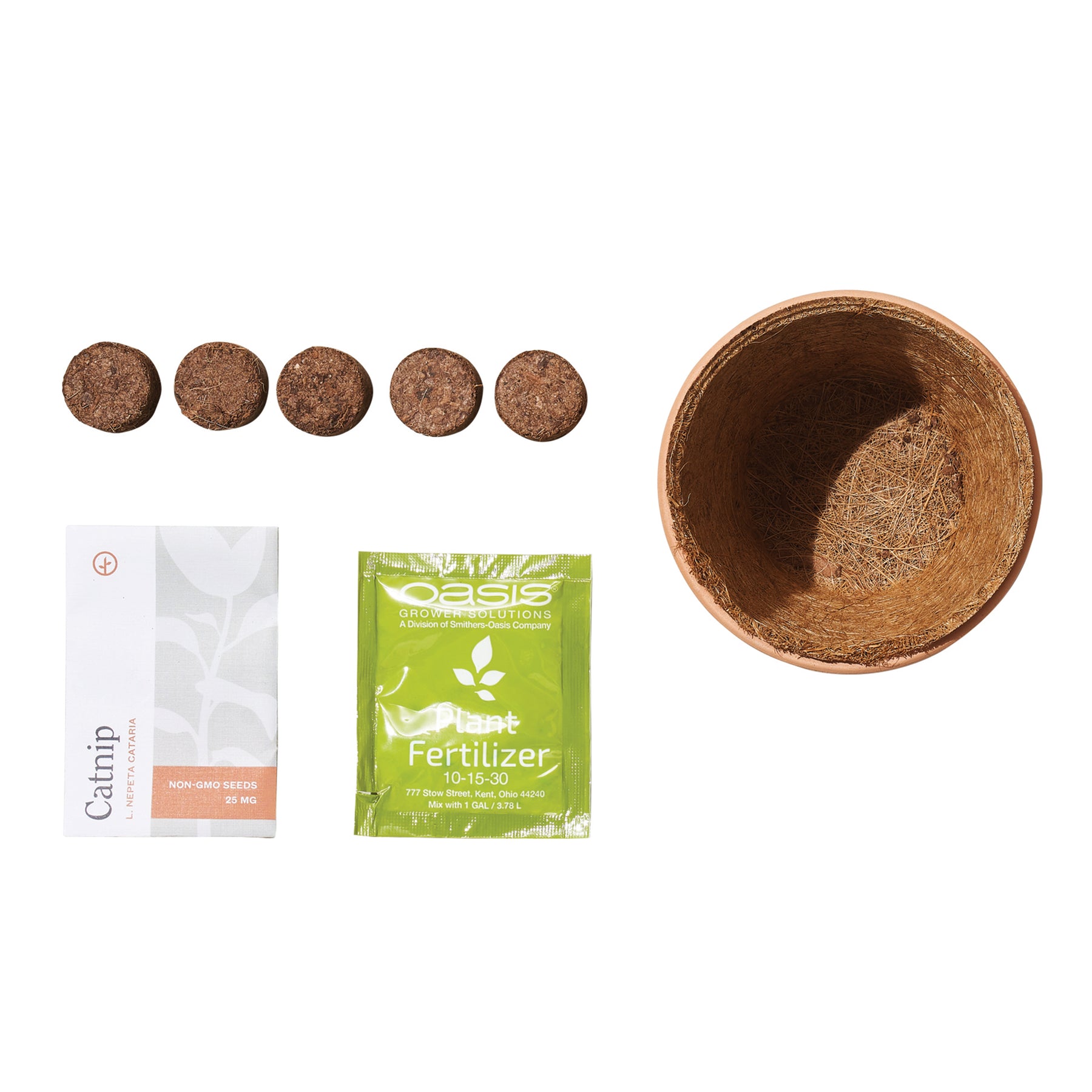 Tiny terracotta grow kit featuring catnip seeds, fertilizer packet, and five compressed soil discs for planting.