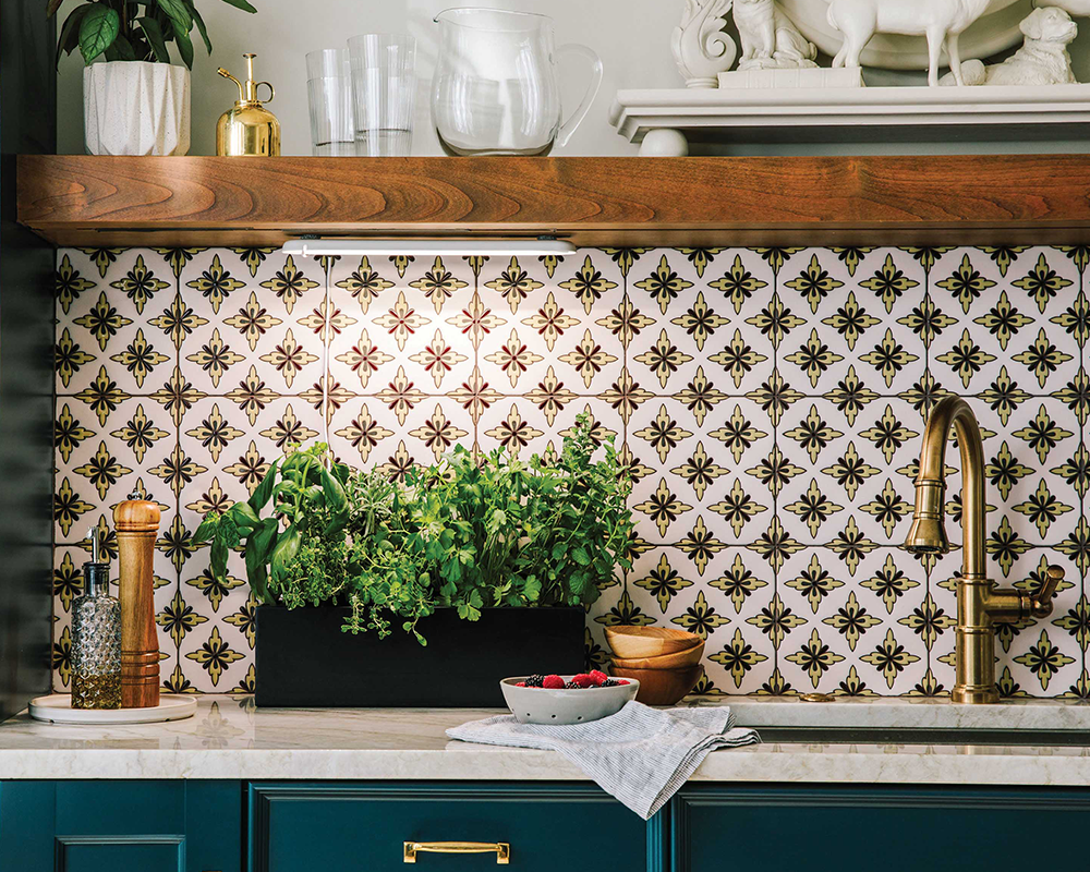 Indoor hydroponic garden with lush herbs on a kitchen counter, patterned backsplash, and gold fixtures.
