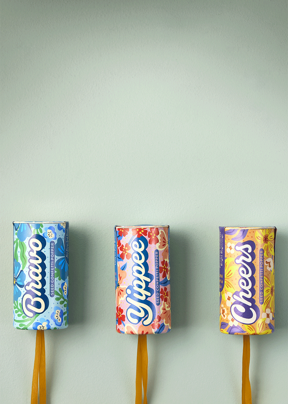 Colorful ChupaSeed seed packets with floral designs, blue, red, and yellow, on a light green background.