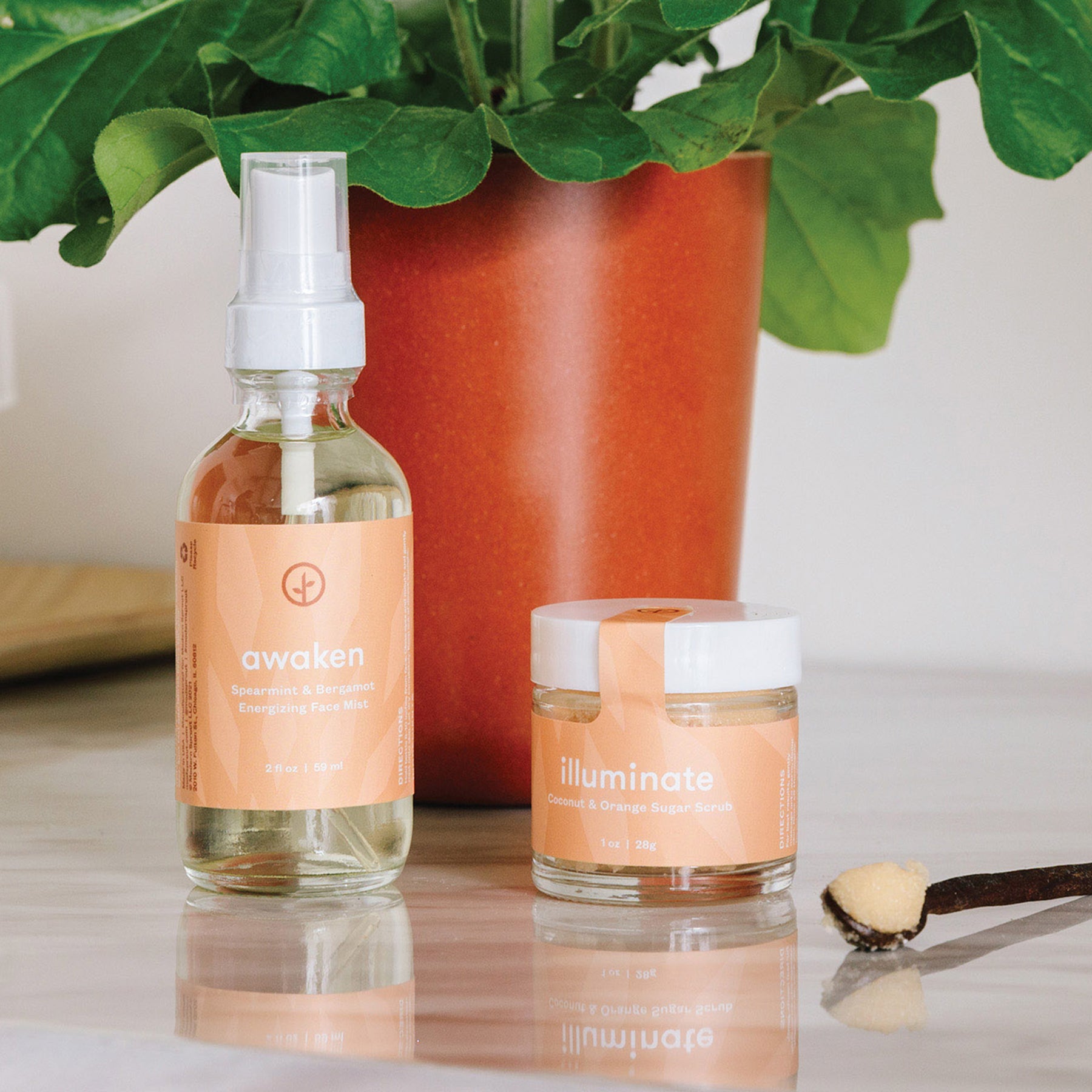 Shine Bright Sugar Scrub 3-pack featuring Illuminate Coconut and Orange Sugar Scrub, Awaken Face Mist, and a spoon.