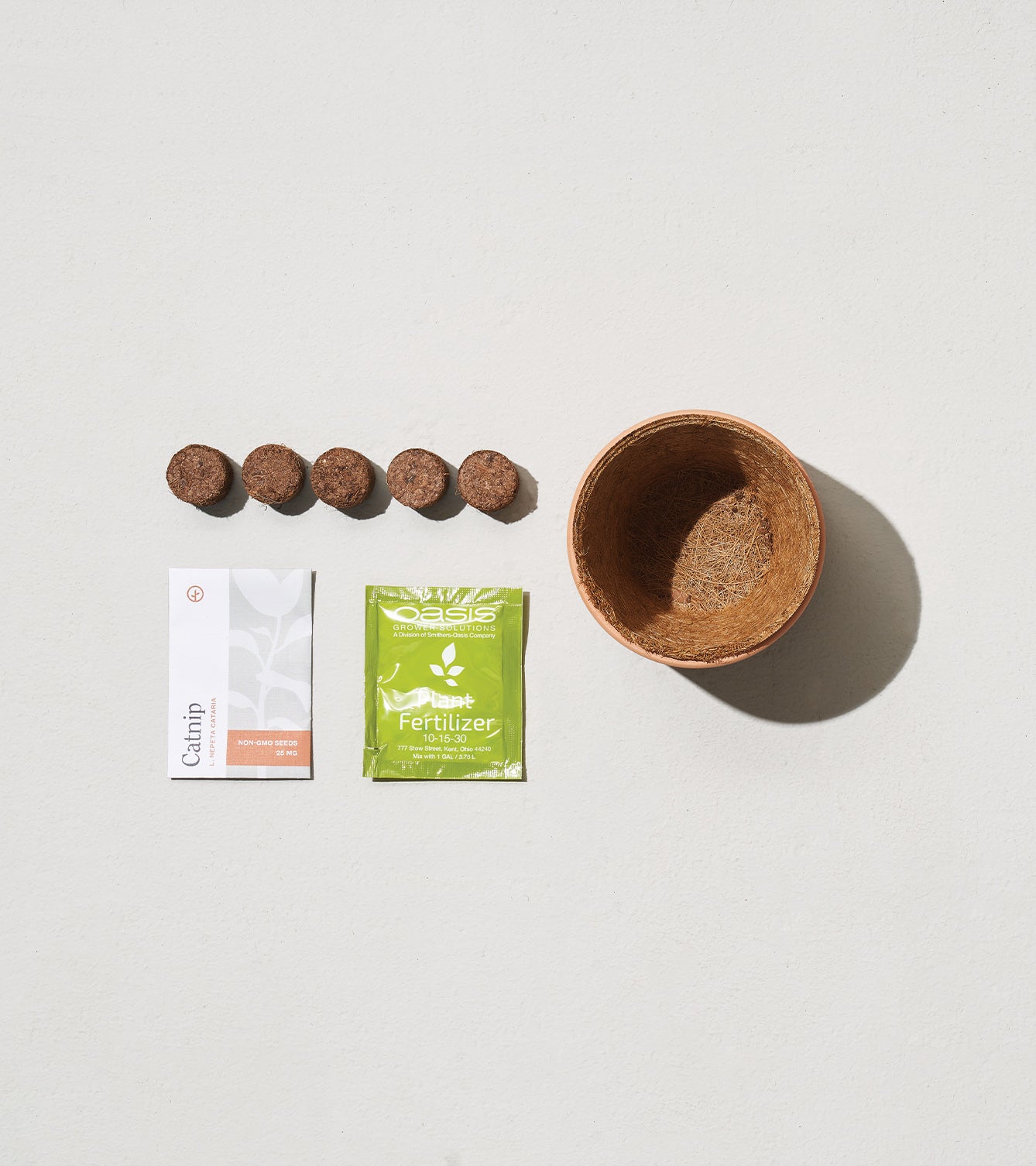 Tiny Terracotta Holiday Kits featuring a small pot, seed pellets, fertilizer packet, and planting instructions.