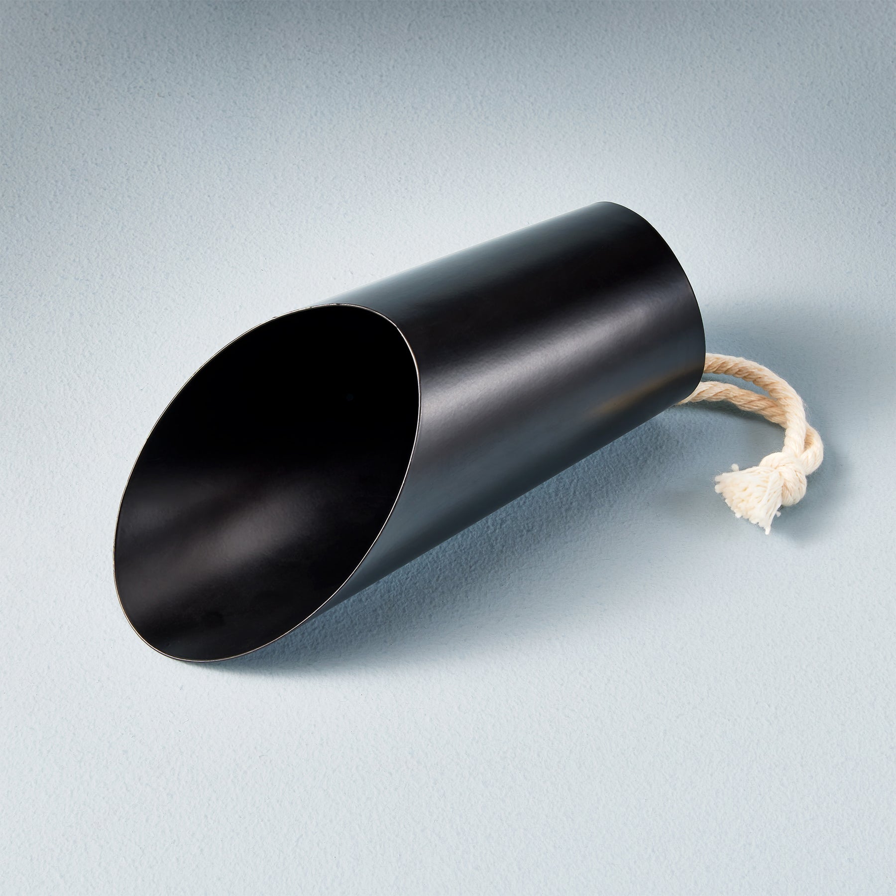 Black metal watering can with a wide spout and a rope handle, designed for easy plant care and watering.