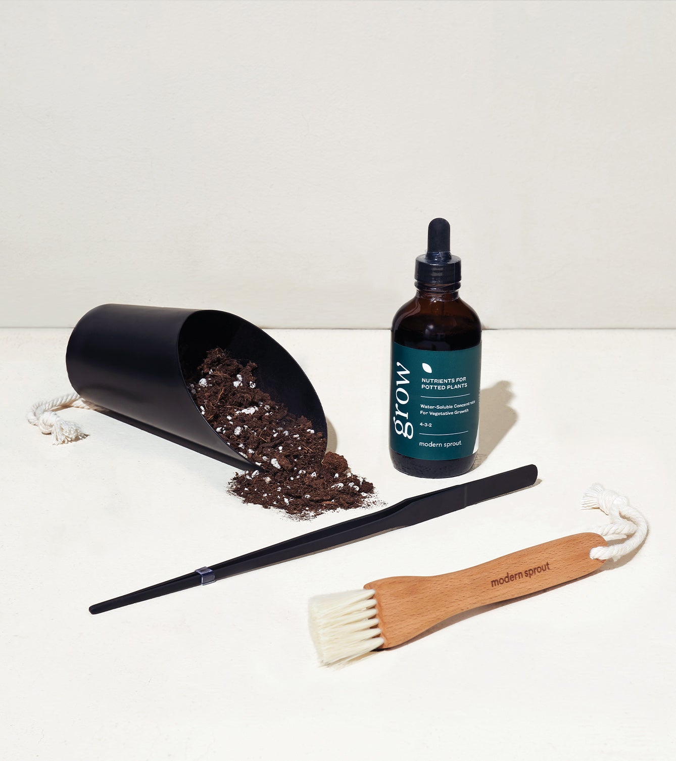 Botanical gift box set featuring a soil scoop, plant care serum, brush, and a planting tool, all designed for plant enthusiasts.