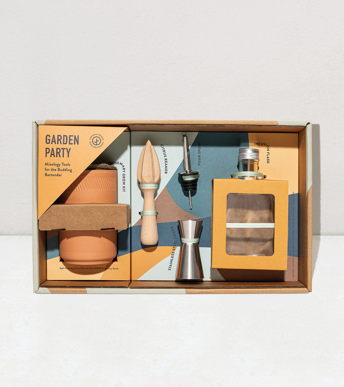 Garden Party botanical gift box set featuring a terracotta pot, wooden plant tool, jigger, and cocktail ingredients.