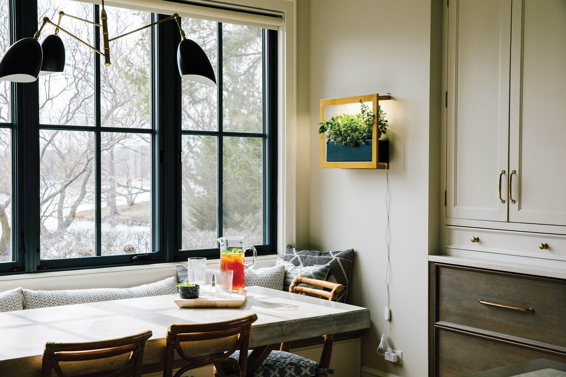 Smart Standard Growframe mounted on a wall in a bright kitchen, featuring lush greenery and a cozy dining area.
