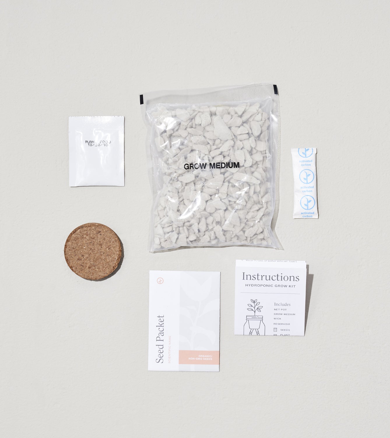 Glow & Grow Kits components including seed packet, grow medium, cork disc, and instruction card arranged on a neutral background.