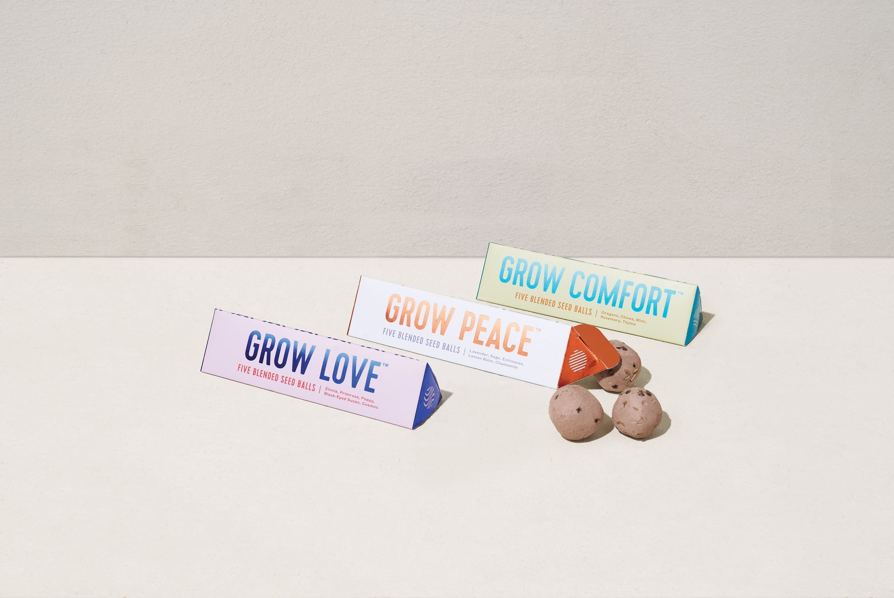 Bright Side Seed Balls packaging displayed with three varieties: Grow Love, Grow Peace, and Grow Comfort, alongside seed balls.