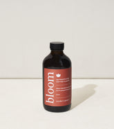 8 oz bottle of bloom plant nutrients for potted plants, featuring a dark label with red accents and a black cap.