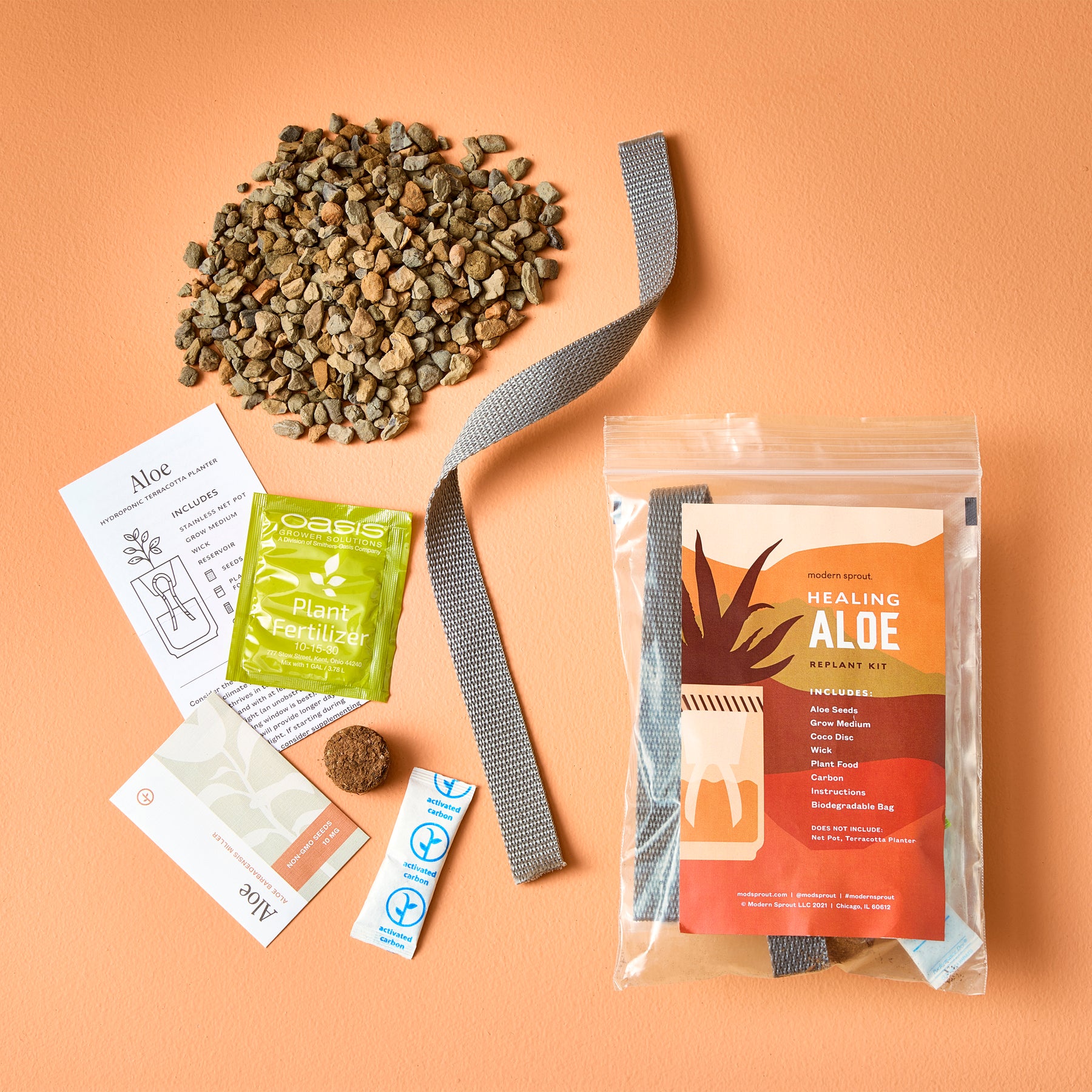 Passive Hydroponic Replant Kit featuring aloe instructions, plant fertilizer, growing medium, and replanting materials on an orange background.