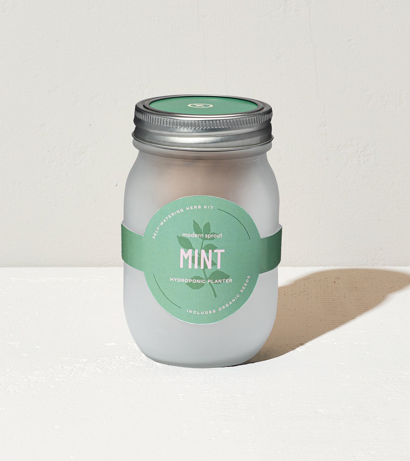 Frosted glass jar labeled Mint, designed for hydroponic planting, includes organic seeds for growing herbs.