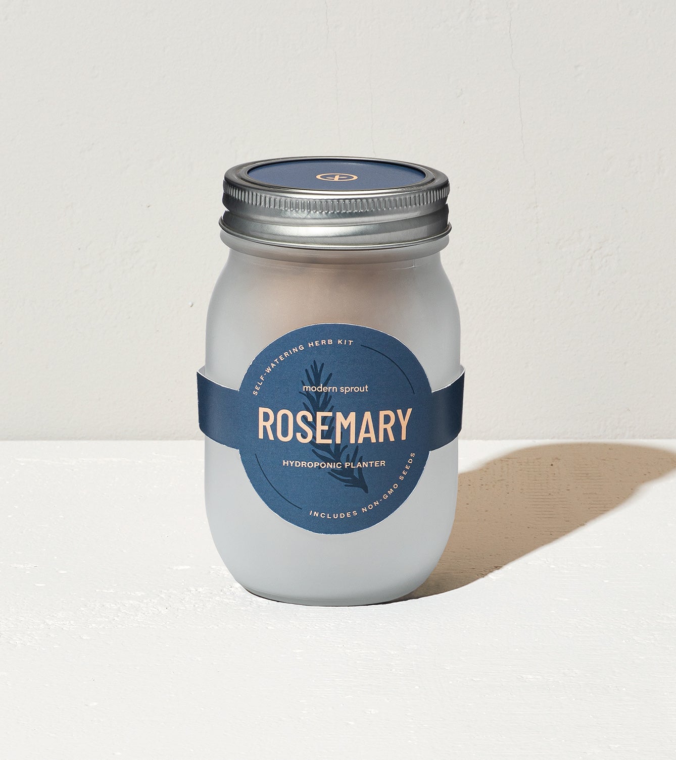 Frosted glass jar labeled "Rosemary" for a hydroponic herb kit, featuring a sleek design and modern branding.