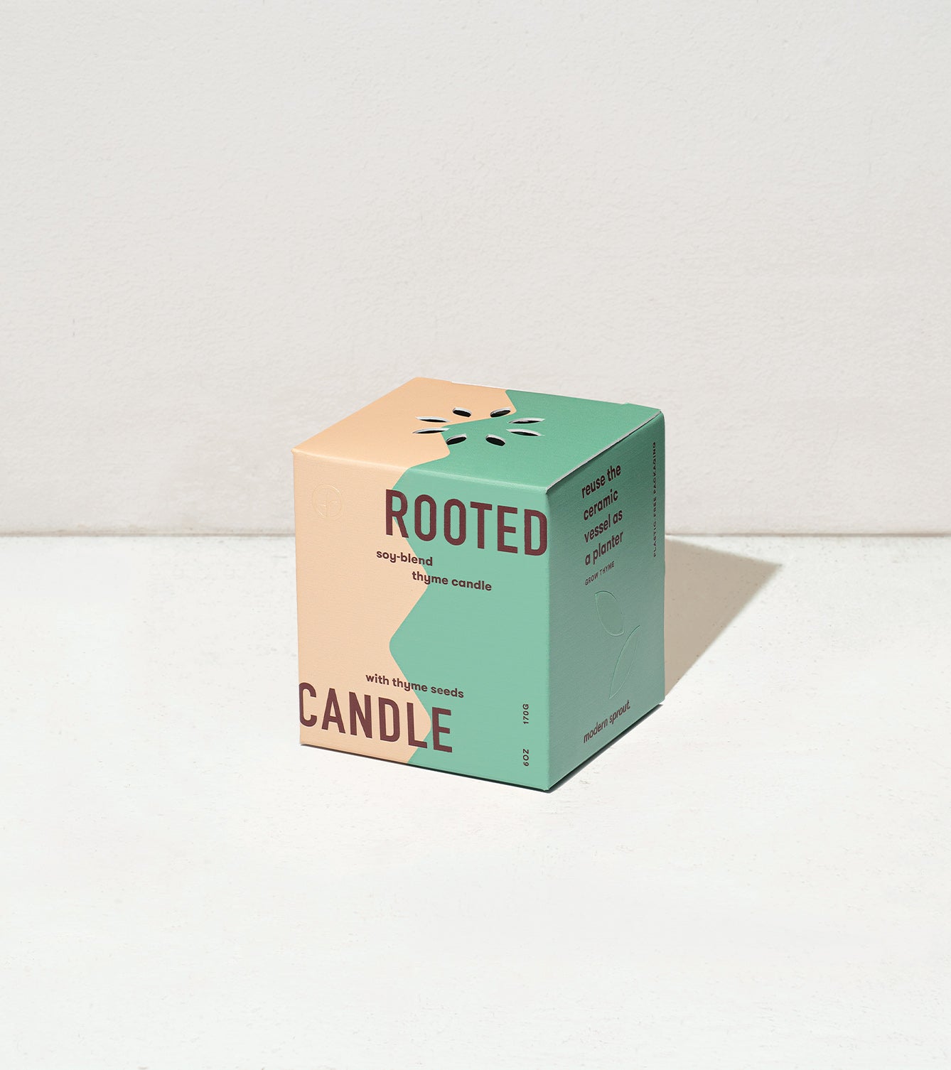 Colorful cube packaging for Rooted Candles features a thyme scent, with a design showcasing thyme seeds.
