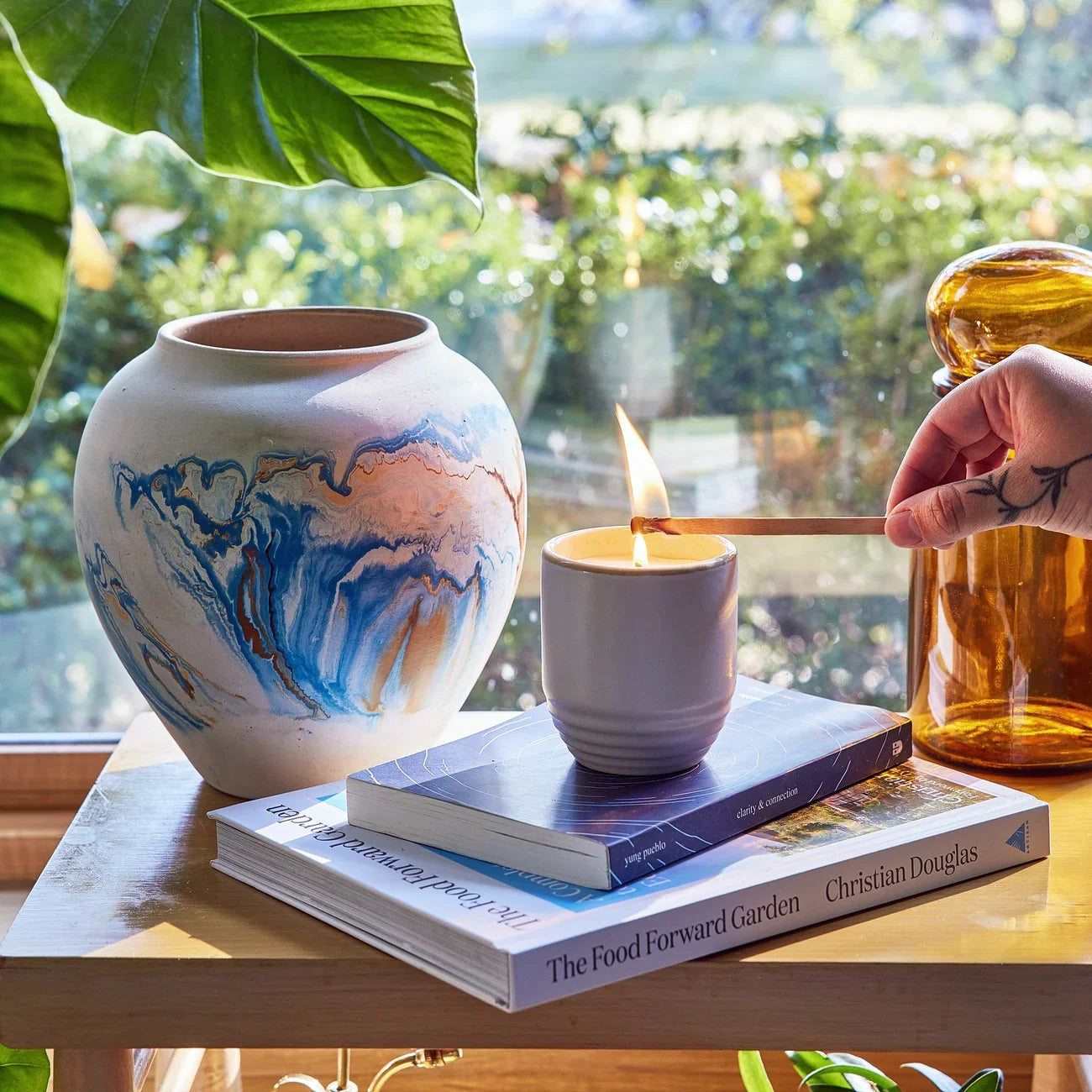 Modern Sprout Garden Vibes Violet Hour candle planter being lit by a sunny window